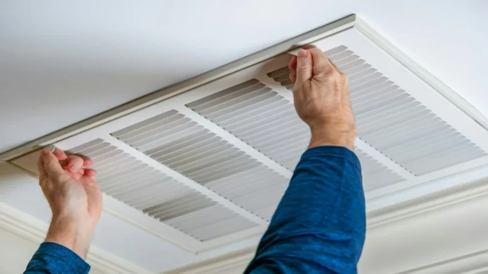HVAC maintenance technician checking an air conditioner filter