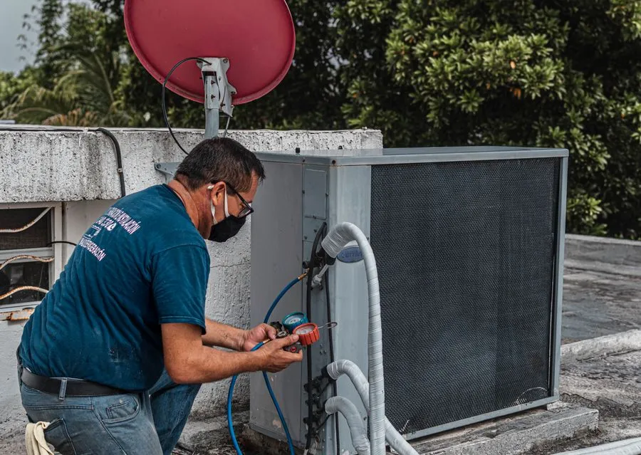 Regular HVAC maintenance by a technician on an outdoor AC unit