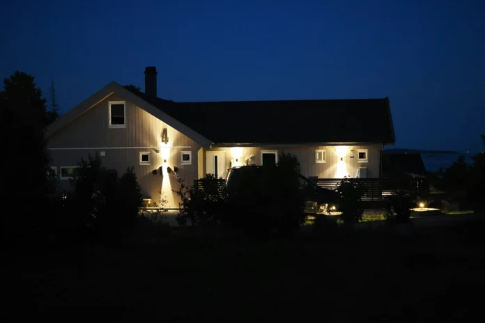 Different types of outdoor lighting fixtures including wall up downlights illuminating a home exterior at night