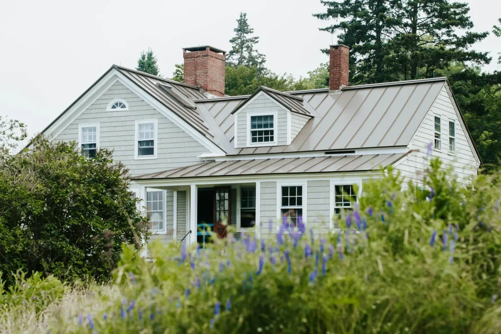A residential house with a metal roof installed to illustrate what is the best roofing material for long term durability.