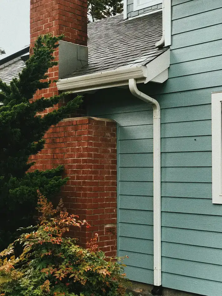 Roof Maintenance Tips: A clean residential gutter and downspout system installed on a home exterior